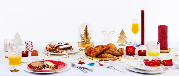 Kerst 2017 – HEMA gedekte kersttafel voor ontbijt met servies, glazen, tafelkleden en servetten en tafeldecoratie in wit en rood kleur. (Foto HEMA  op DroomHome.nl)