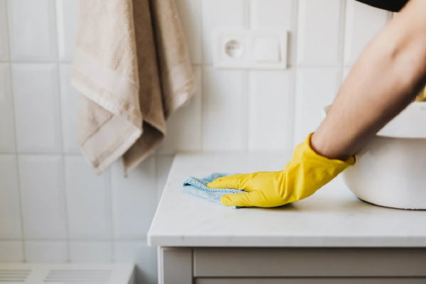 Badkamer schoonmaken tips: badmeubel met microvezeldoekje (Foto Karolina Grabowska, Pexels.com  op DroomHome.nl)