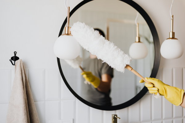 Badkamer schoonmaken tips: lampen en spiegel met plumeau (Foto Karolina Grabowska, Pexels.com  op DroomHome.nl)