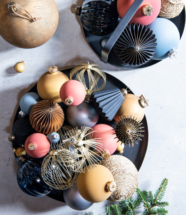 Kersttrends 2021 Intratuin – Intratuin kerstboom decoratie met mat roze, aarde tinten, blauw, geel Intratuin kerstballen en in natuurlijke materialen. (Foto Intratuin  op DroomHome.nl)