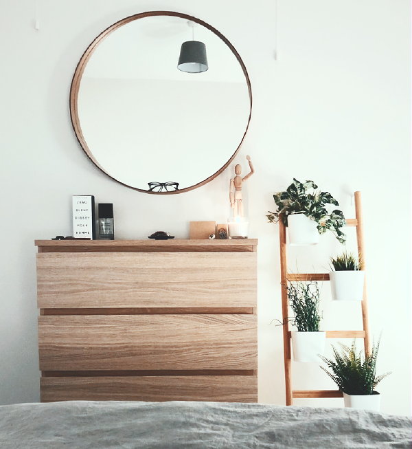 Comfortabele slaapkamer – Ladenkast met spiegel er boven en houten ladder met planten in hangende potjes (Foto James Lindsay,  Unsplash.com  op DroomHome.nl)