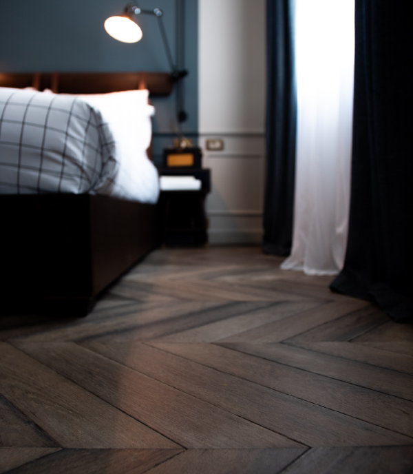 Vloeren trends 2022 – Donker eiken PVC visgraat vloer in de slaapkamer (Foto Ralph Darabos, Unsplash.com  op DroomHome.nl)