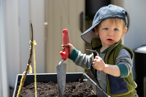 6 Tips voor het creëren van een gezinstuin – Kind speelt in een moestuintje (Foto: Christopher Luther, Unsplash  op DroomHome.nl)