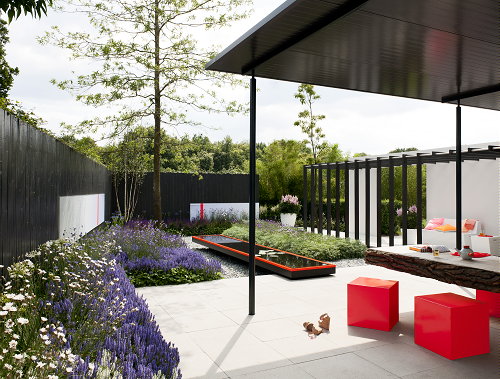 Tuintrend - Tuinontwerp Let Me Glow Garden - Strakke Tuin met Vrolijk Gekleurde Design Tuinmeubels, Vijver, Veranda & Grijs Groene Tuinplanten. MEER Tuintrends... (Foto Perscentrum Tuinen  op DroomHome.nl)