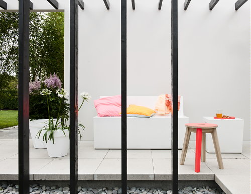 Tuintrend - Tuinontwerp Let Me Glow Garden - Strakke Tuin met Vrolijk Gekleurde Design Tuinmeubels & Grijs Groene Tuinplanten op de Veranda. MEER Tuintrends... (Foto Perscentrum Tuinen  op DroomHome.nl)