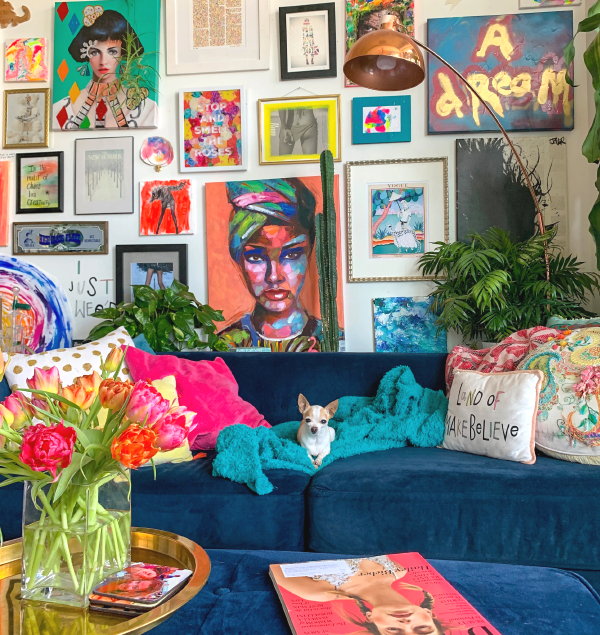 Je interieur persoonlijk maken met je eigen persoonlijke items – Kleurrijke schilderijen, foto’s kussens, planten en plaids (Foto: Steph Wilson, Unsplash  op DroomHome.nl)